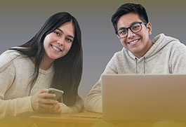Pareja de estudiantes de informática e inglés escriben resumen de clases y usan su laptop dentro de centro de computo